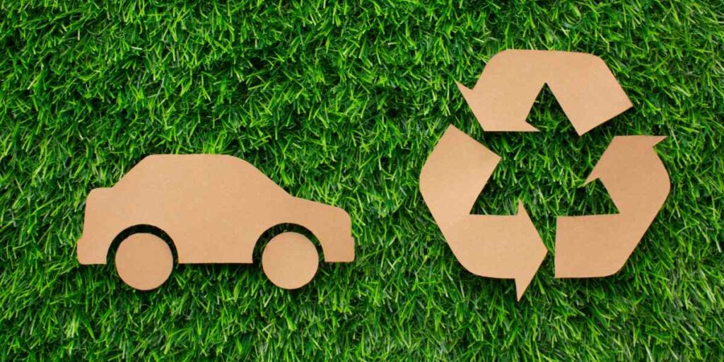 Foto de carro e simbolo de reciclagem representando mobilidade sustentável.